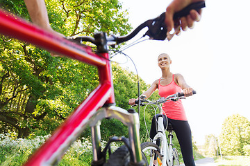 Image showing close up of happy couple riding bicycle outdoors