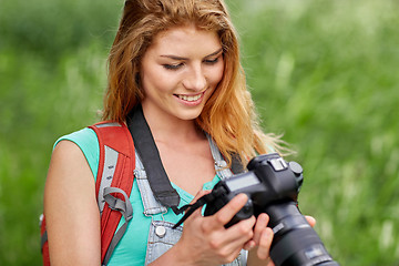 Image showing happy woman with backpack and camera outdoors