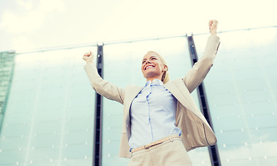 Image showing young smiling businesswoman over office building