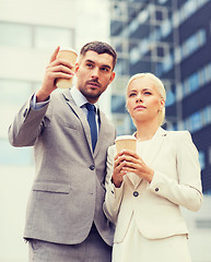 Image showing serious businessmen with paper cups outdoors