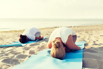 Image showing close up of couple making yoga exercises outdoors