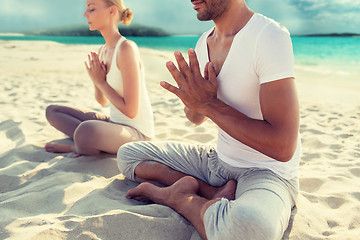 Image showing smiling couple making yoga exercises outdoors