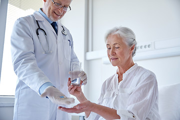 Image showing doctor giving medicine to senior woman at hospital