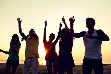 Image showing smiling friends dancing on summer beach