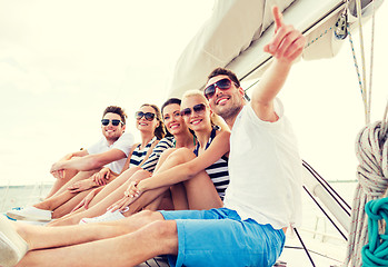 Image showing smiling friends sitting on yacht deck