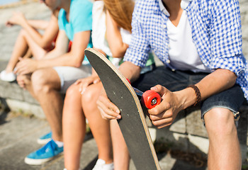 Image showing close up of friends with longboard on street