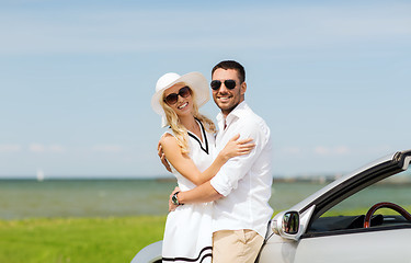 Image showing happy man and woman hugging near car at sea