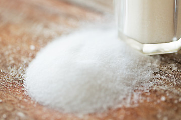 Image showing close up of white salt cellar on wooden table