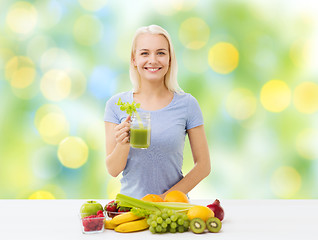 Image showing smiling woman drinking juice or shake at home