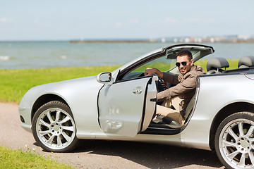Image showing happy man opening door of cabriolet car outdoors