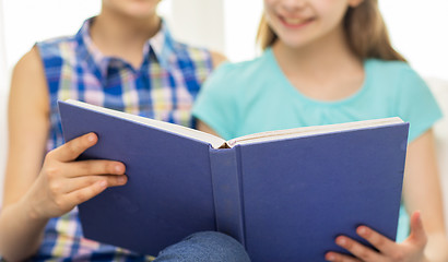 Image showing close up of happy girls reading book at home