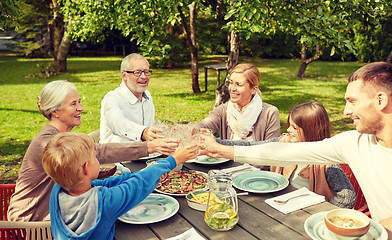 Image showing happy family having dinner in summer garden