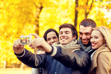 Image showing group of smiling men and women making selfie