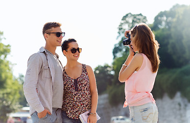 Image showing happy friends with camera taking picture outdoors