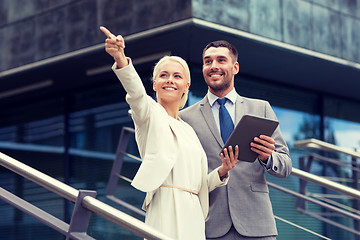 Image showing smiling businessmen with tablet pc outdoors