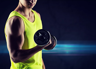 Image showing close up of young man with dumbbell flexing biceps