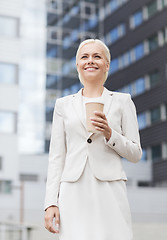 Image showing smiling businesswoman with paper cup outdoors