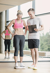 Image showing smiling man and woman with scales in gym