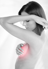 Image showing woman checking breast for signs of cancer