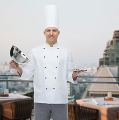 Image showing happy male chef cook opening cloche