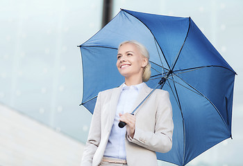 Image showing young smiling businesswoman with umbrella outdoors