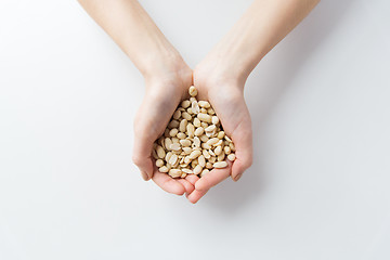 Image showing close up of woman hands holding peeled peanuts