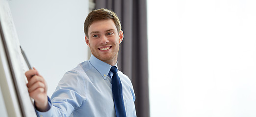 Image showing smiling businessman on presentation in office