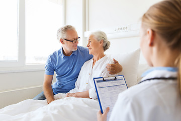 Image showing senior woman and doctor with clipboard at hospital