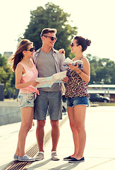 Image showing smiling friends with map and city guide outdoors