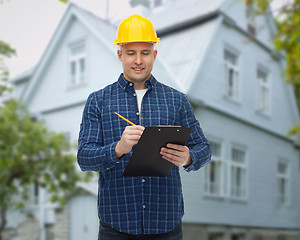 Image showing smiling male builder in helmet with clipboard