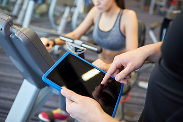 Image showing close up of trainer hands with tablet pc in gym