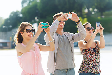 Image showing smiling friends with smartphone taking picture