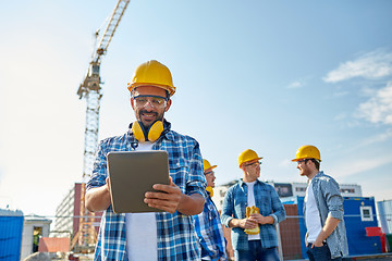 Image showing builder in hardhat with tablet pc at construction