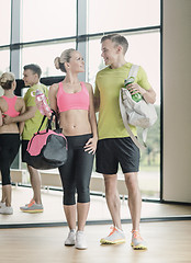 Image showing smiling couple with water bottles in gym