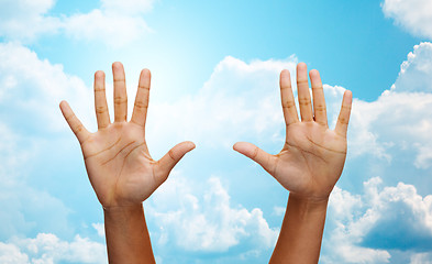 Image showing two african hands making high five over blue sky