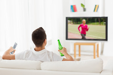 Image showing man watching sport on tv and drinking beer at home
