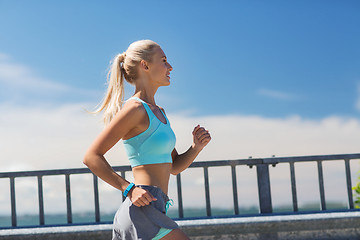 Image showing smiling young woman running outdoors