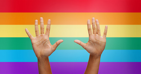 Image showing palms of human hands thumbs up over rainbow