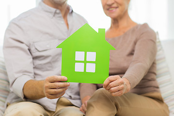 Image showing close up of happy senior couple with green house