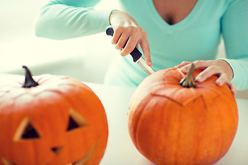 Image showing close up of woman with pumpkins at home