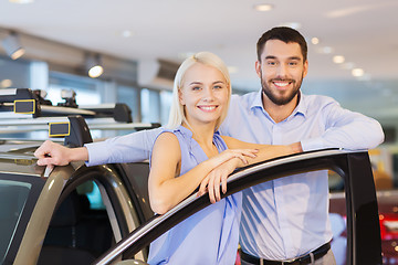 Image showing happy couple buying car in auto show or salon