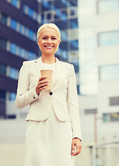 Image showing smiling businesswoman with paper cup outdoors