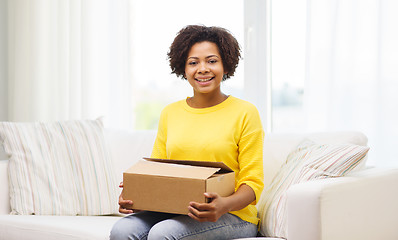 Image showing happy african young woman with parcel box at home