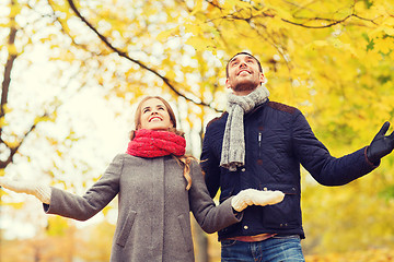 Image showing smiling couple looking up in autumn park