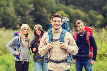 Image showing group of smiling friends with backpacks hiking