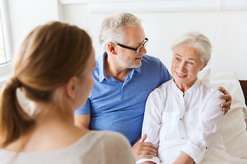 Image showing happy family visiting senior woman at hospital