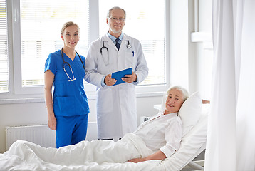 Image showing doctor and nurse visiting senior woman at hospital