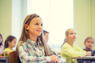 Image showing group of school kids with notebooks in classroom