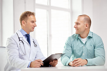 Image showing male doctor and patient with clipboard at hospital