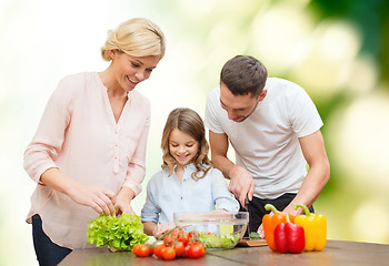 Image showing happy family cooking vegetable salad for dinner